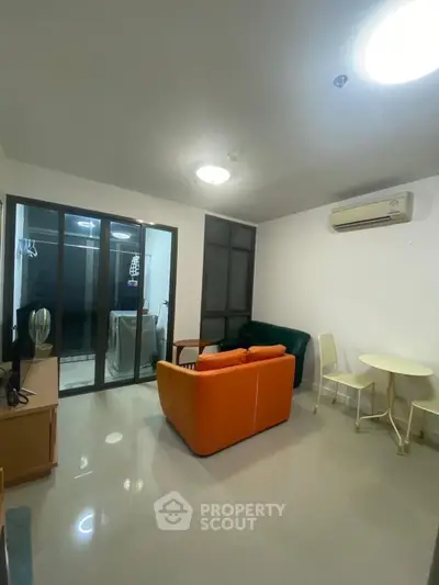 Modern living room with vibrant orange sofa and sleek glass doors leading to balcony.