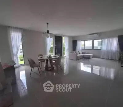 Spacious modern living room with elegant dining area and large windows.