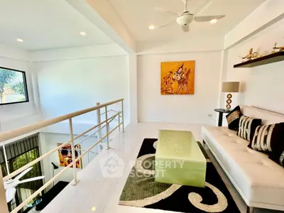 Modern living room with stylish decor, white sofa, and artistic wall painting in a bright, airy space.