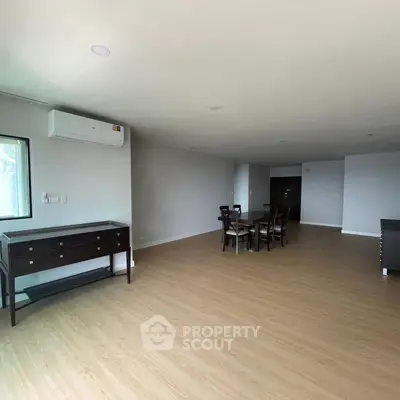 Spacious modern living room with wooden flooring and elegant furniture.