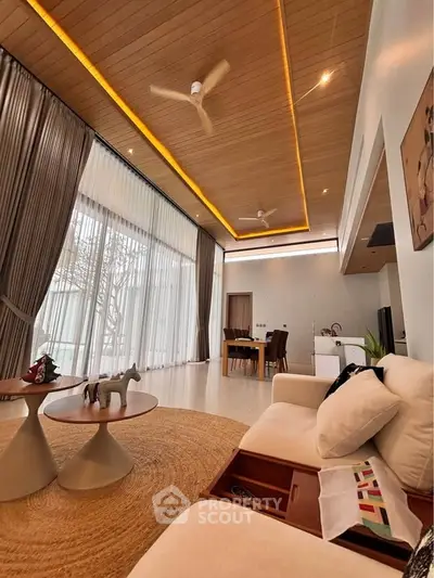 Spacious modern living room with high ceilings, elegant decor, and large windows for natural light.