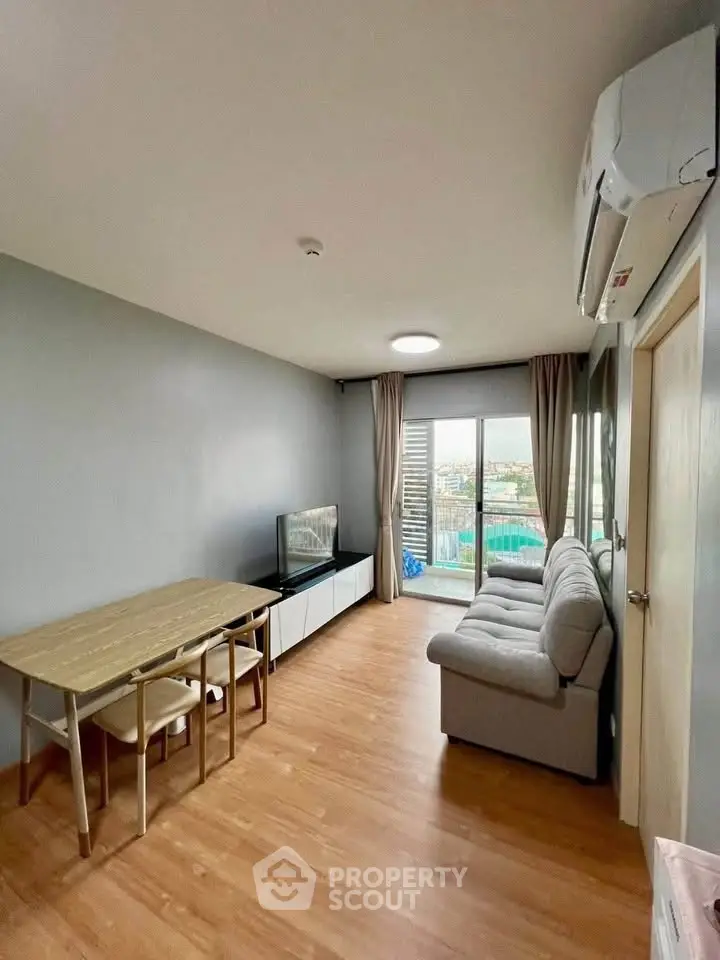Modern living room with wooden flooring, cozy sofa, and dining area, featuring a balcony with city view.