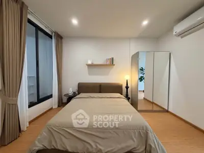 Modern bedroom with cozy bed, mirrored wardrobe, and elegant lighting in a stylish apartment.