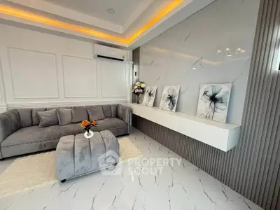 Luxurious modern living room with elegant decor and plush gray furniture.
