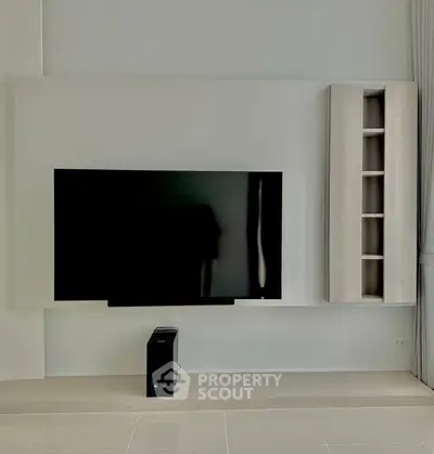 Modern living room with sleek TV setup and minimalist shelving unit.