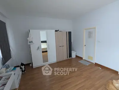 Spacious bedroom with wooden flooring and modern wardrobe