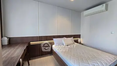 Modern bedroom with sleek design and air conditioning, featuring a comfortable bed and stylish wooden furniture.