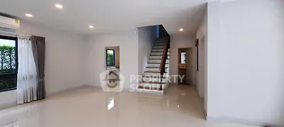 Spacious modern living room with staircase and large windows, perfect for family gatherings.