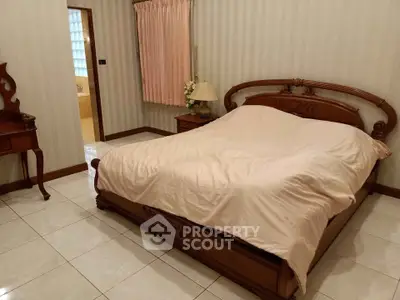 Elegant bedroom with classic wooden bed and soft lighting, perfect for a cozy retreat.