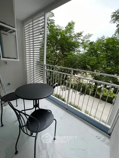 Charming balcony with stylish furniture and lush green view, perfect for relaxation.