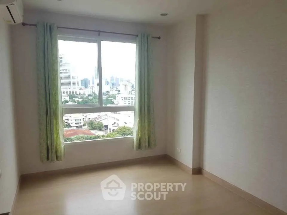 Bright empty room with large window and city view, perfect for customization.