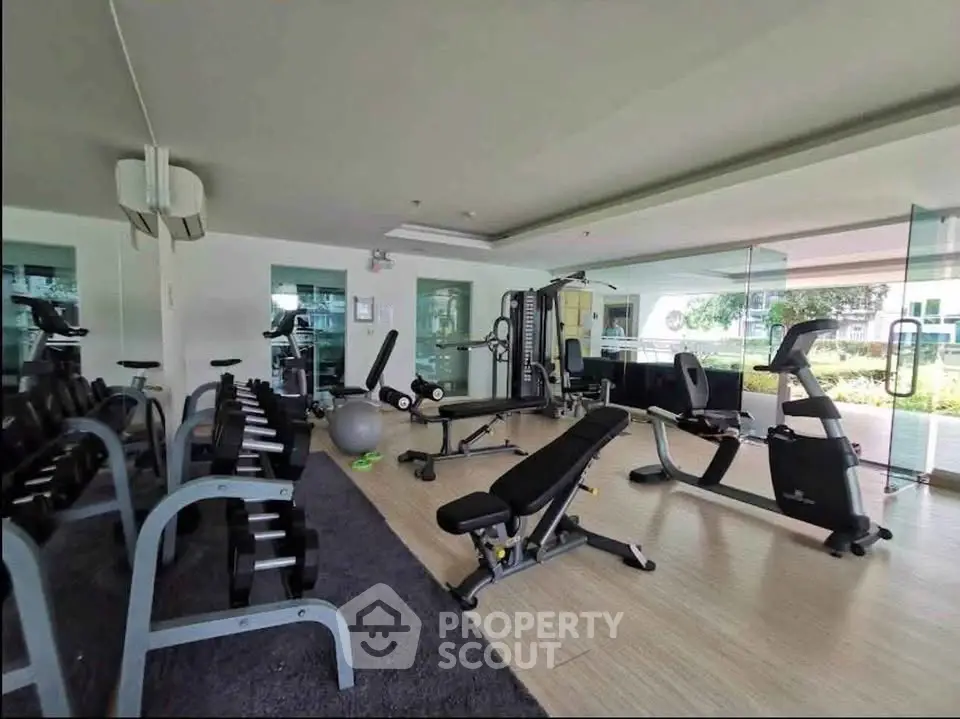 Modern gym with state-of-the-art fitness equipment and large windows offering garden views.