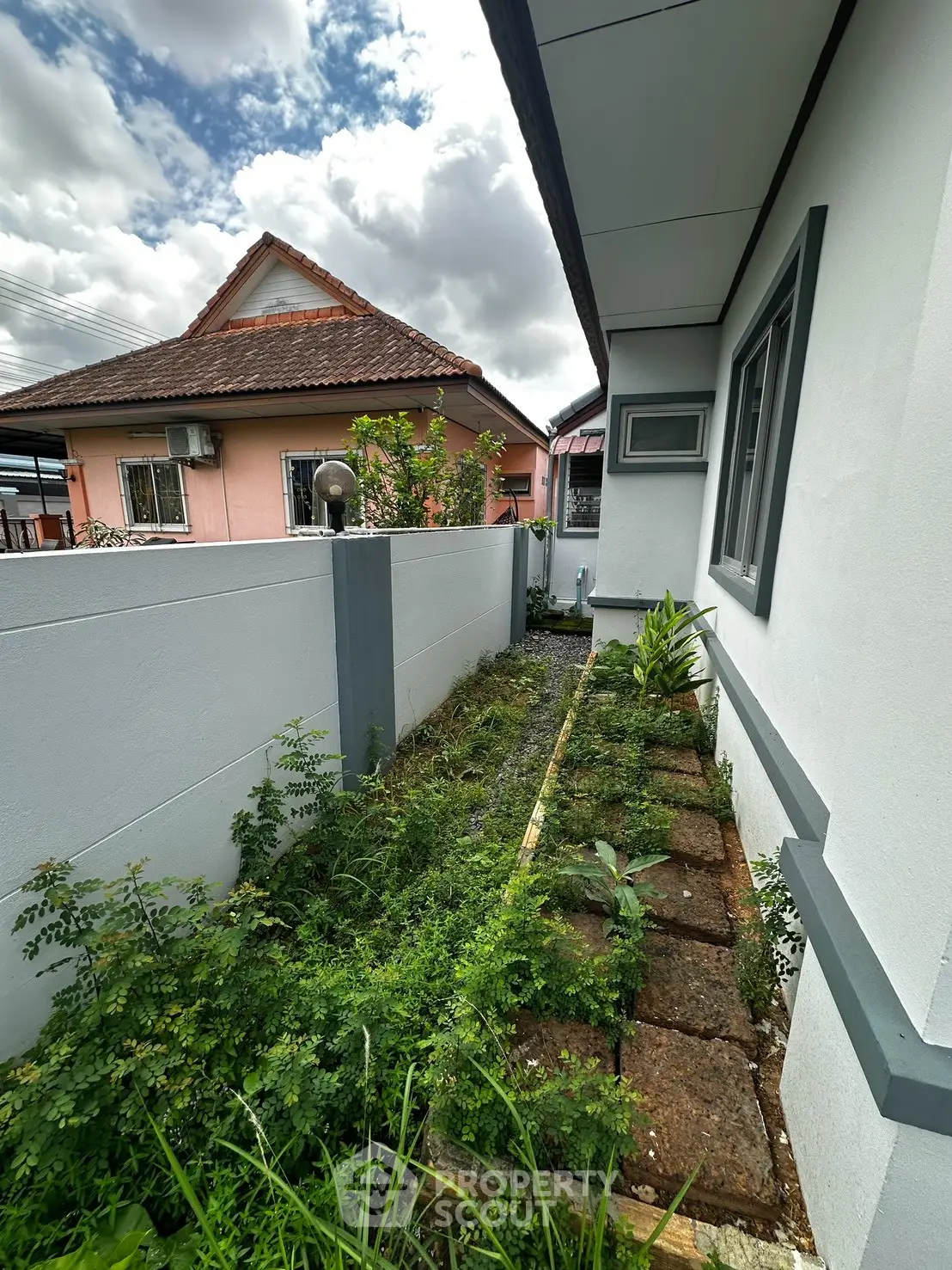 Charming side garden with lush greenery and pathway in residential property