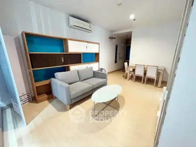 Modern living room with stylish furniture and dining area in open layout apartment.