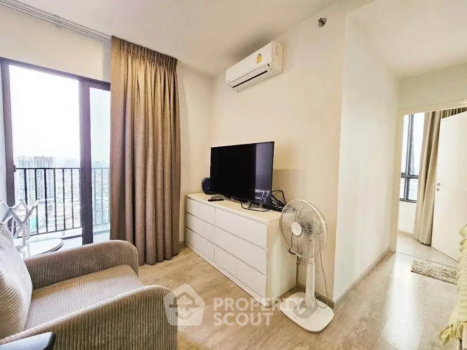 Modern living room with balcony view, featuring air conditioning and sleek furniture.