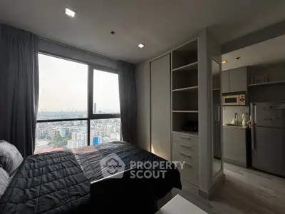 Modern bedroom with city view and adjacent kitchen in high-rise apartment