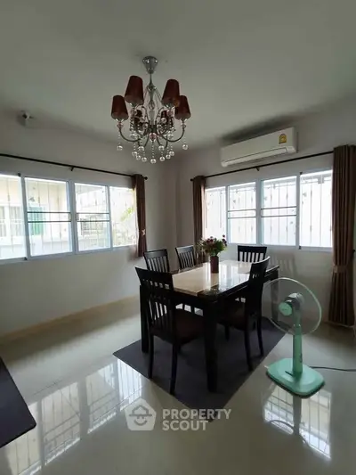 Elegant dining room with chandelier and natural light, perfect for family gatherings.