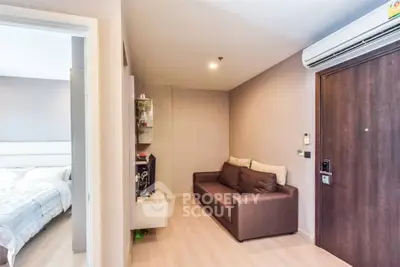Cozy apartment interior with modern sofa and air conditioning, adjacent to a bright bedroom.