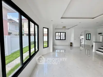 Spacious modern living room with large windows and glossy tile flooring