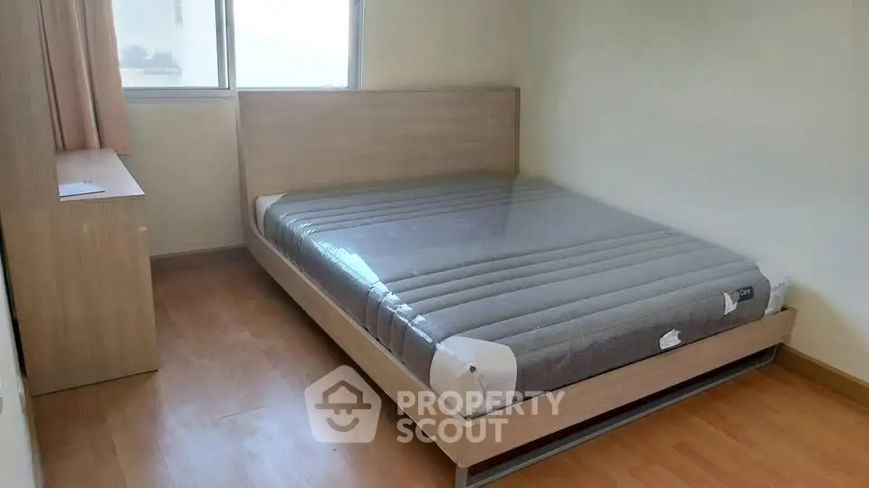 Cozy bedroom with new mattress and wooden flooring, perfect for restful nights.