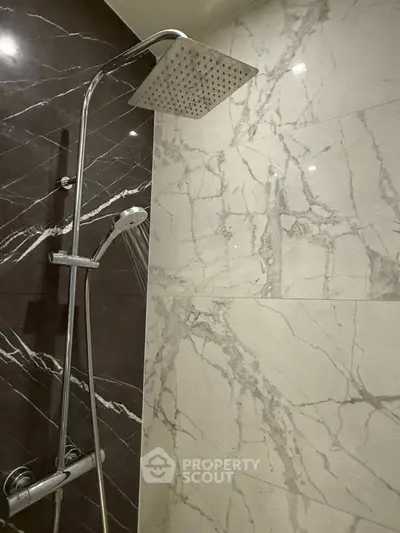 Luxurious marble-tiled bathroom with modern rainfall showerhead