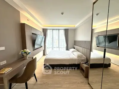 Modern bedroom with large windows, stylish decor, and wall-mounted TV in a luxury apartment.