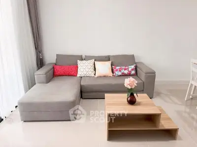 Modern living room with stylish gray sectional sofa and chic wooden coffee table.