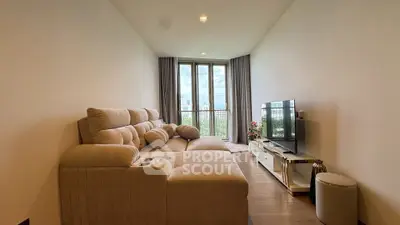 Spacious living room with plush sofa and large window offering scenic views.