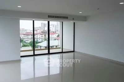 Spacious modern living room with large windows offering city views and ample natural light.