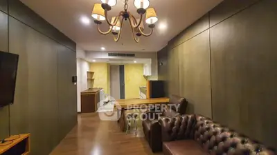 Stylish living room with leather sofa and modern kitchen in open layout apartment.