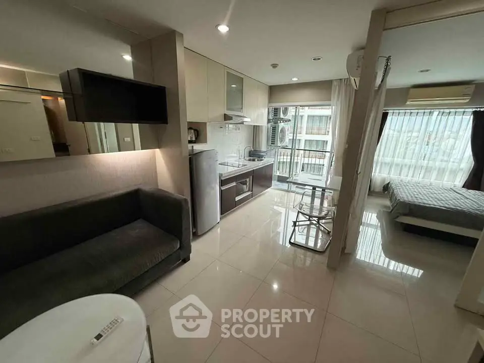 Modern open-plan living room with kitchen and bedroom in stylish apartment.