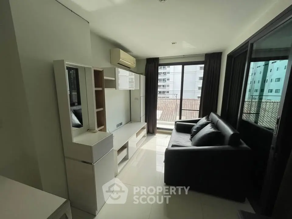 Modern living room with sleek furniture and large windows offering ample natural light.