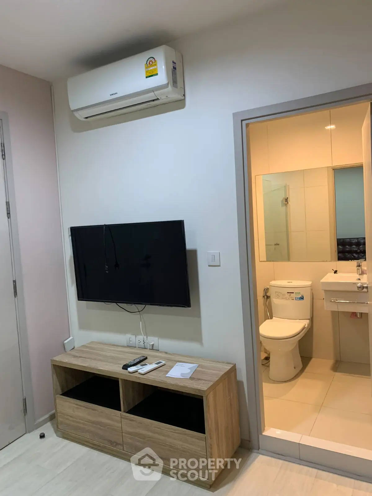 Modern apartment interior with wall-mounted TV and bathroom view