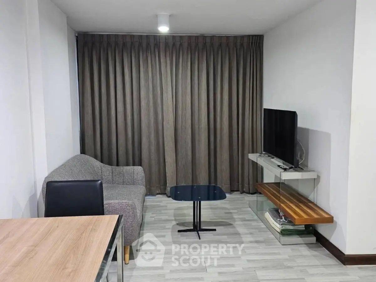 Cozy living room with modern furniture and TV, perfect for relaxation.