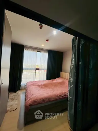 Cozy bedroom with large window and pink bedding in modern apartment