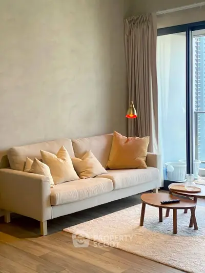 Stylish living room with cozy sofa, modern decor, and natural light from large window.