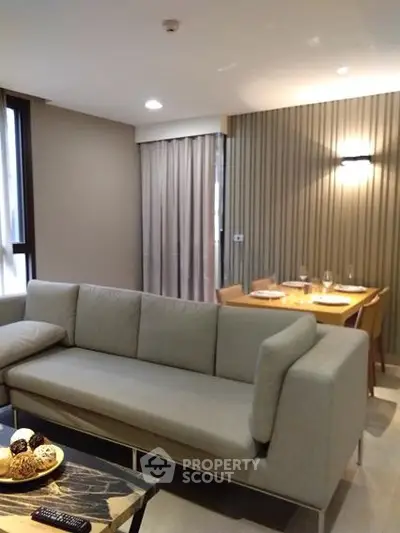 Modern living room with stylish sofa and dining area in open layout apartment.