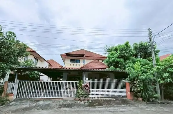 Charming suburban house with gated entrance and lush greenery