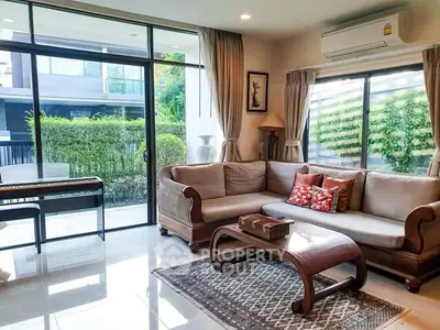 Spacious living room with large windows and elegant furniture in a modern home.