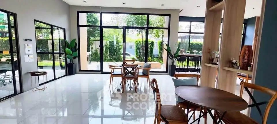 Spacious modern living area with large windows and garden view, perfect for relaxation and entertaining.