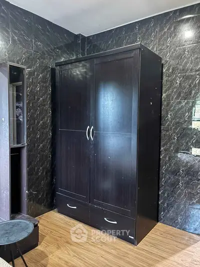 Spacious storage solution with sleek dark wood wardrobe in modern interior setting.