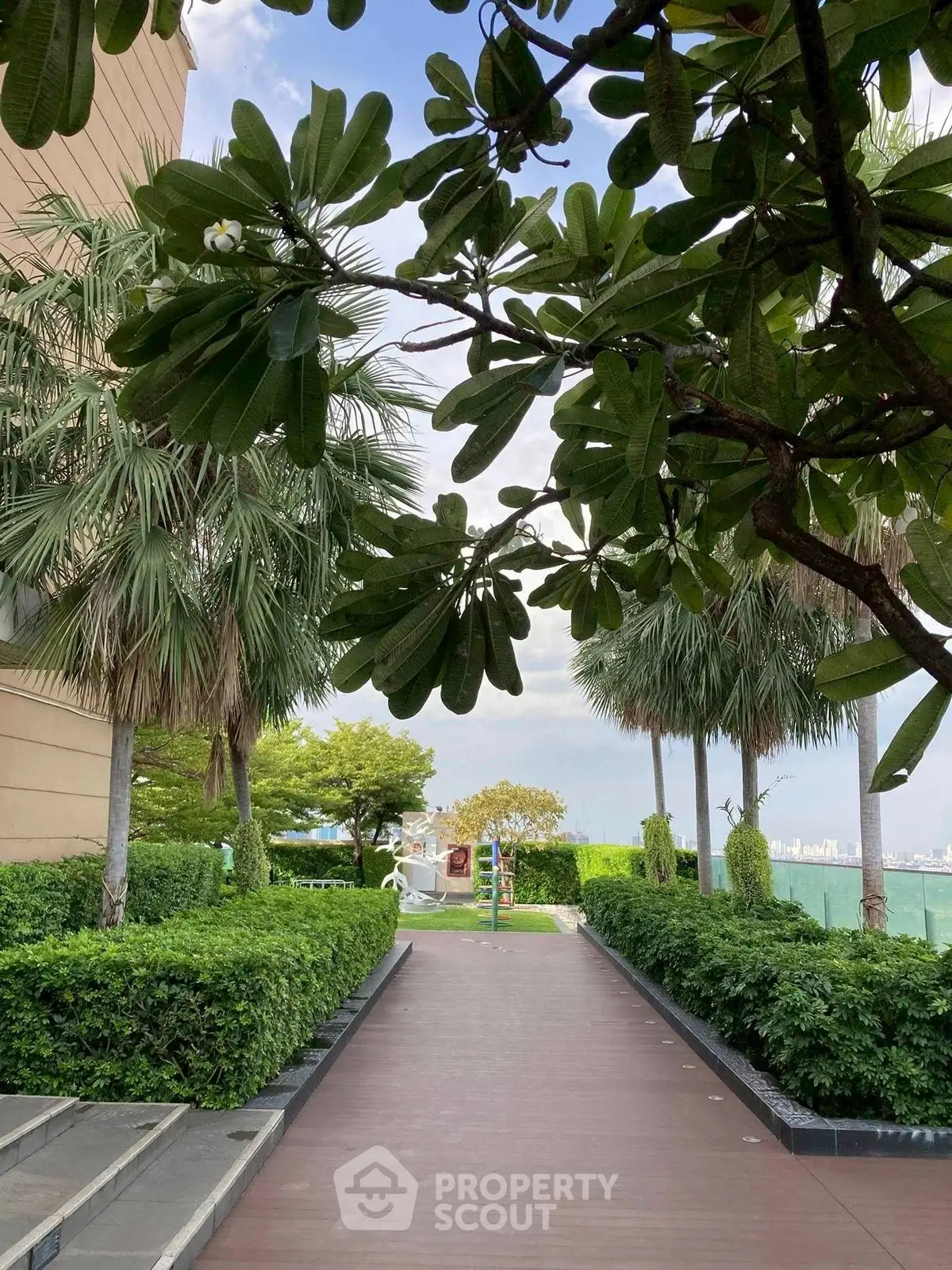 Lush garden pathway with city skyline view, perfect for serene living.