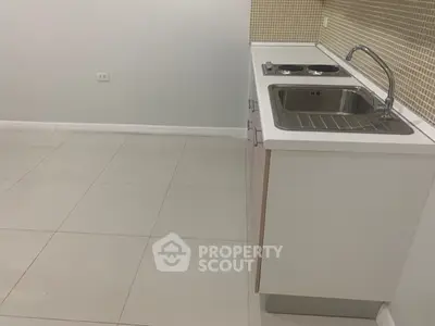 Modern minimalist kitchen with sleek white cabinetry and tiled backsplash