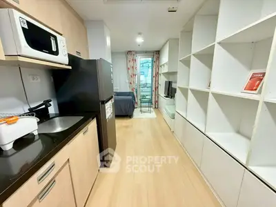 Modern studio apartment with sleek kitchen and cozy living area, perfect for urban living.