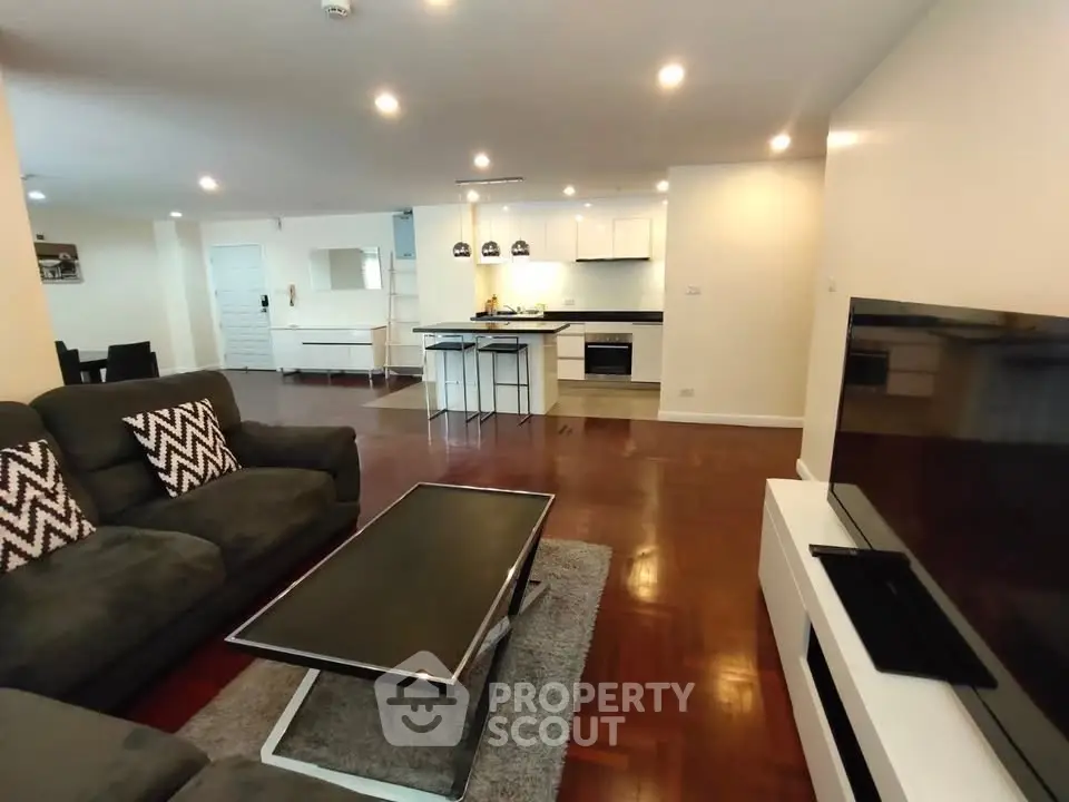 Spacious open-plan living room with modern kitchen and cozy seating area