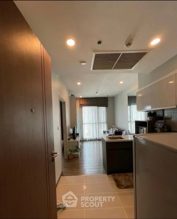 Modern apartment entrance leading to a cozy living area with natural light and stylish decor.