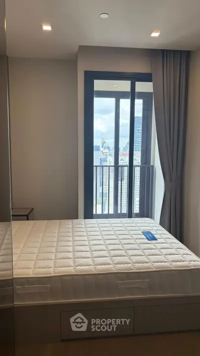 Modern bedroom with city view and floor-to-ceiling windows in a high-rise apartment.