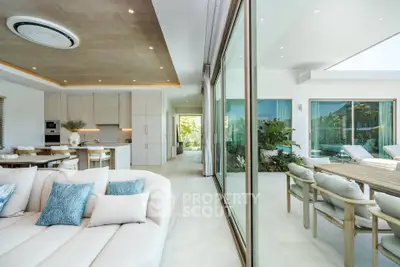 Luxurious open-plan living room with modern kitchen and spacious outdoor patio.