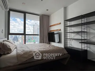 Modern bedroom with city view, featuring sleek shelving and wall-mounted TV.
