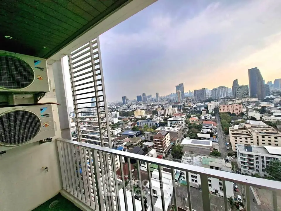 Stunning cityscape view from a high-rise balcony with air conditioning units, perfect for urban living.